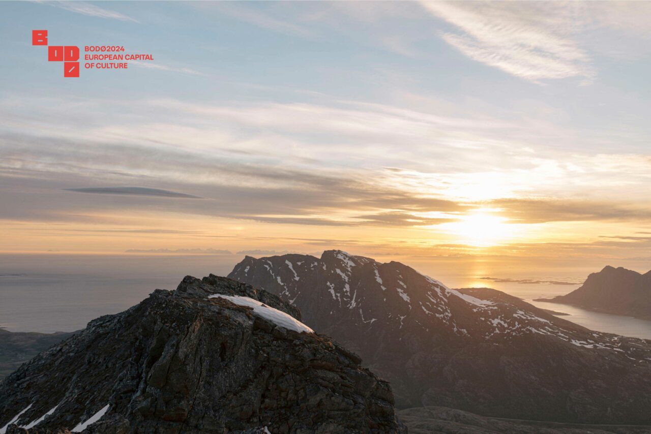 Et høyt snødekt fjell med solnedgangen i bakgrunnen. Foto