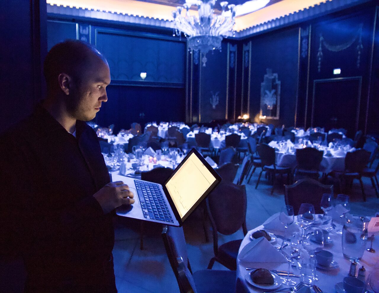 Mann med PC i forkant av eventlokale. Foto
